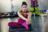 envato-young-woman-doing-stretching-exercises-on-a-yoga-m-imp